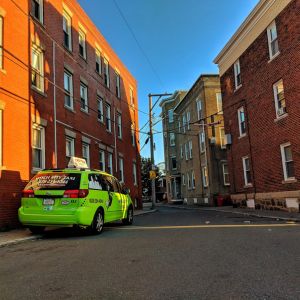 Image of multi-story houses and green cab